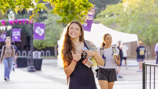 Student walking on campus with Axes Up