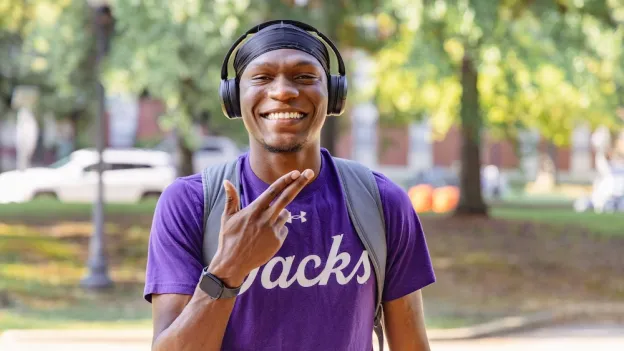 Student wearing headphone and showing Axes Up