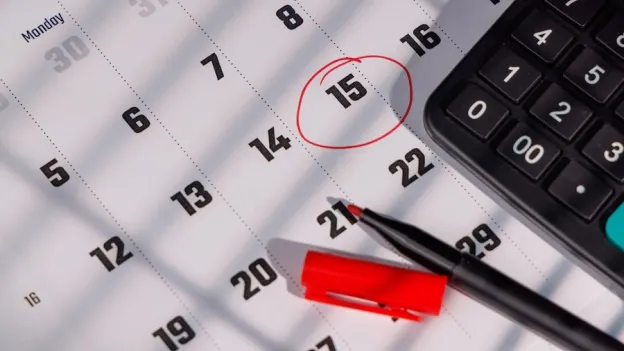 Closeup of a calendar with the 15th circled in red