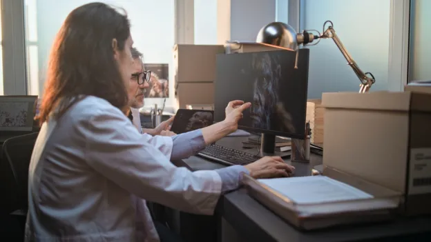 Scientists studying a 3D model on computer screen