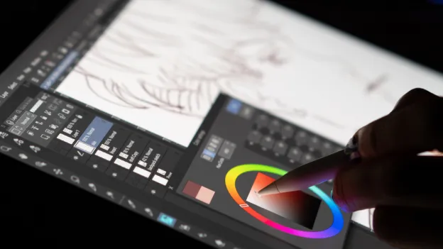 The hands of an artist selecting color on a digital drawing tablet