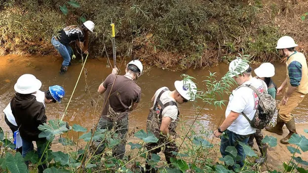 students using the creek for lab study in hydrology