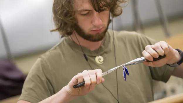 Student creating jewelry with pliers