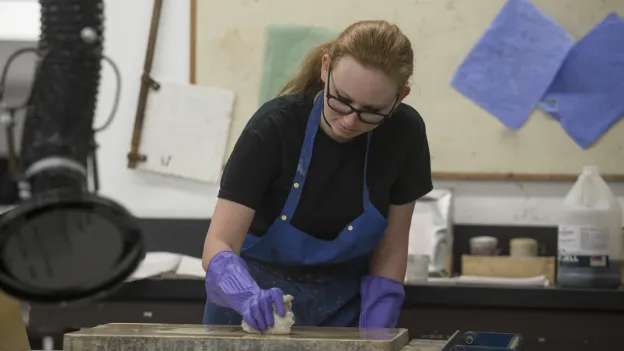 Student wearing gloves while working with chemicals