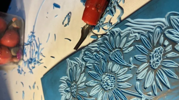 Linocut Printmaking Process carving a linolium block for printing