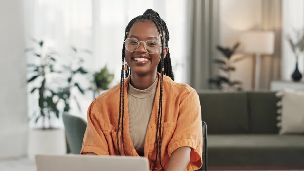 woman working at laptop and smiling at the camera