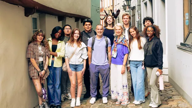 SFA students and faculty stand together in a cobblestone alley in Latvia.