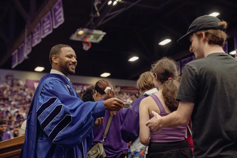 Dr. Kent Willis hands new Lumberjacks a silver challenge coin