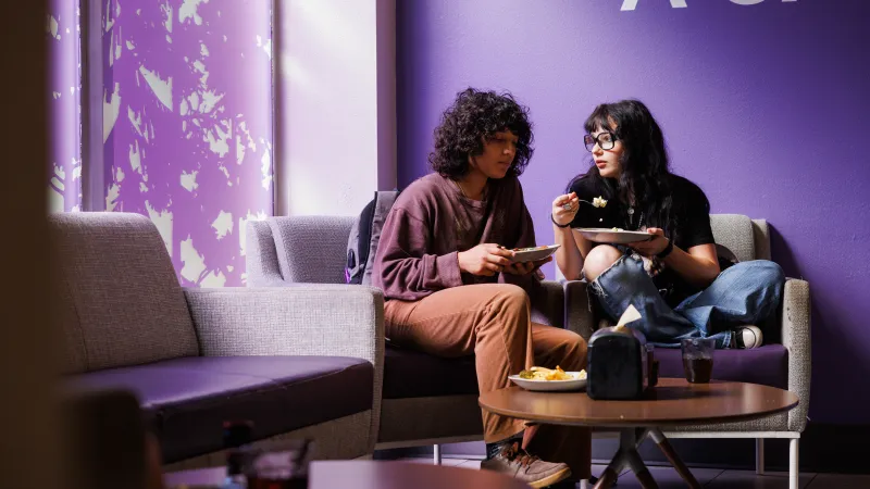 Two students chatting while eating together
