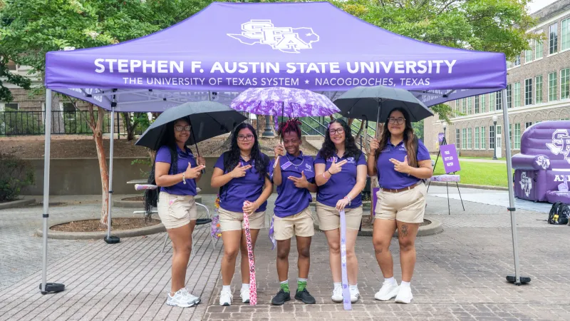 Student leaders with umbrellas in the rain