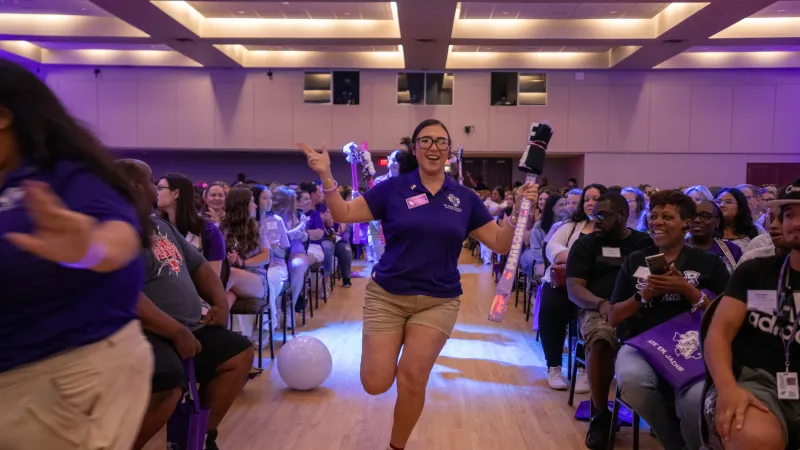 Student orientation leader running through crowd