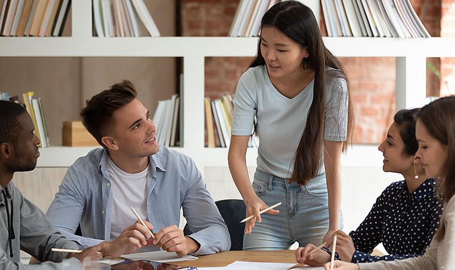female student standing and explaining to group of seated students