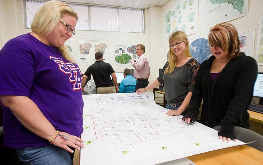 A group of women standing over a table with a map