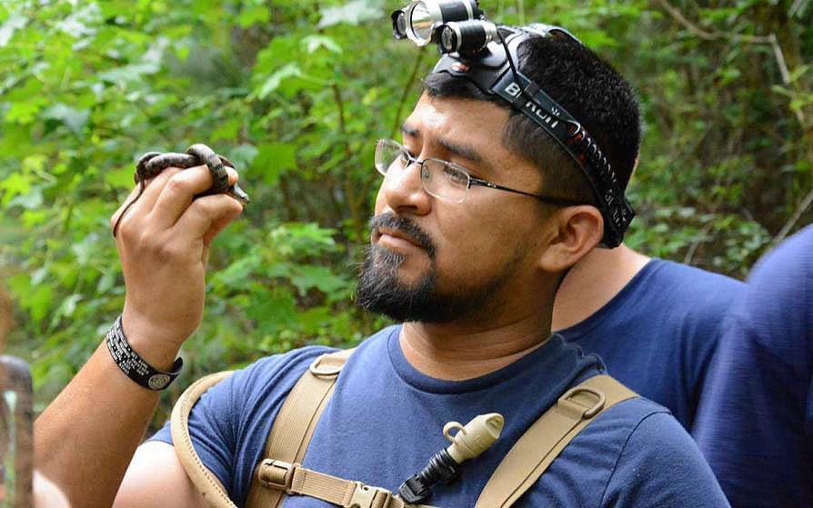 forestry student holding a small snake