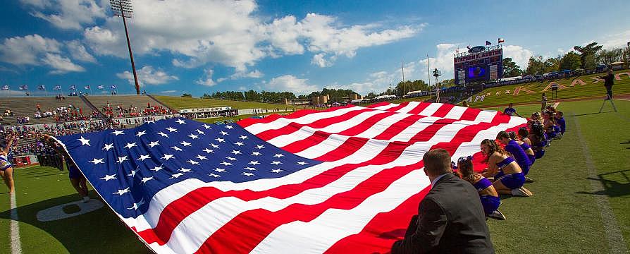 American flag spread out on football field