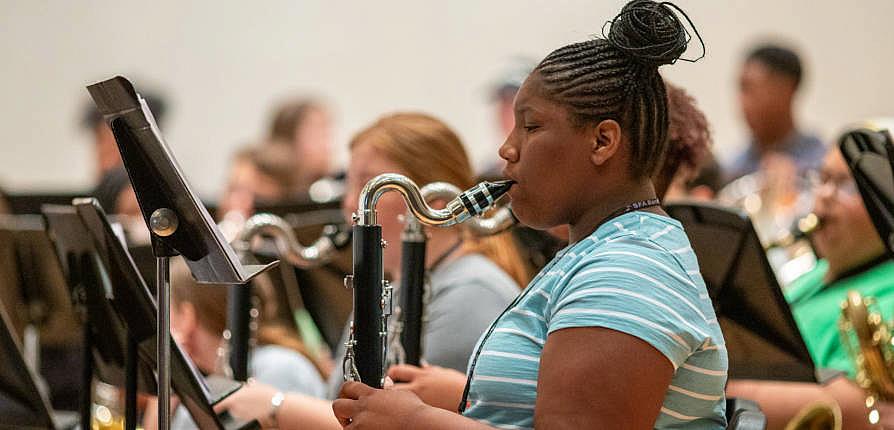 A camper plays clarinet during an ensemble rehearsal
