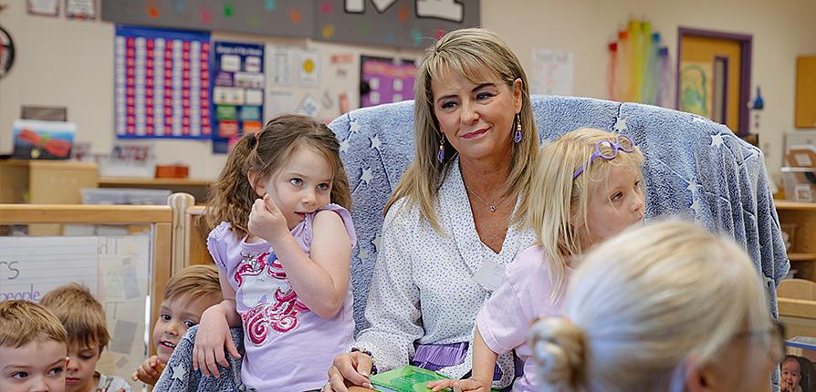 Former teacher and current SFA first lady Kristi Weaver reads "The Giving Tree" to children ages 4 to 6 at the SFA Charter School. Photo by Lizeth Garcia