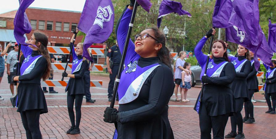 Members of the LMB march in a parade with flags