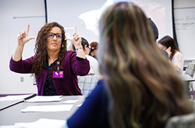 Two students using American sign language to communicate