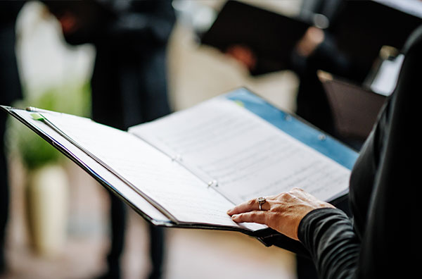 Someone holding a binder of sheet music