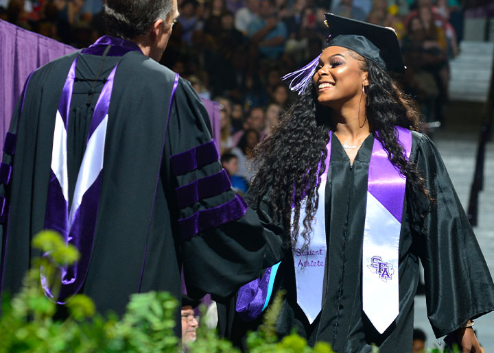 Student walking across stage at commencement