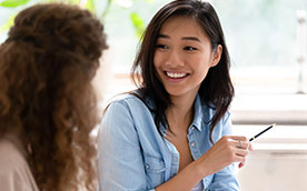 two young women smiling and conversing