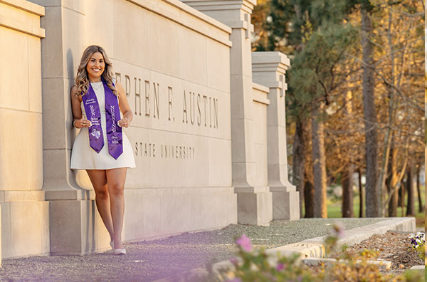 Student posing in front of sign