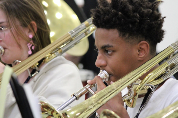 A trombonist plays in an ensemble during a band camp rehearsal