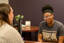 Student talking with an advisor in an office setting