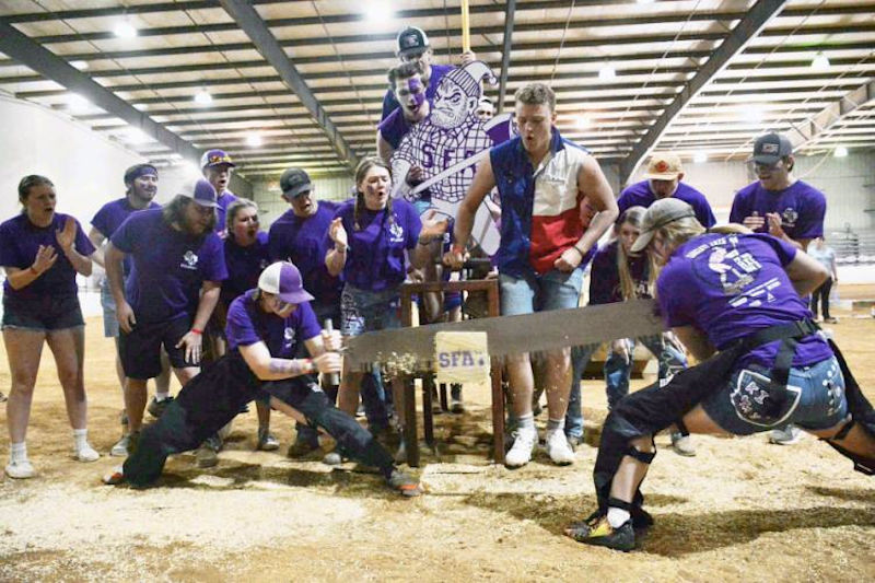 Members of the Sylvans saw a log during a competition