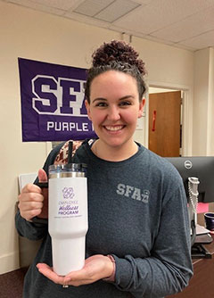 Level 1 Winner holding Wellness Program coffee thermos prize