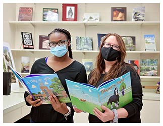 Kimberly Verhines, director of the SFA Press, right, holds “Blazer’s Taxi” by Una Belle Townsend, while student assistant Jakayla Murphy holds the press’ latest book, “A Day at SFA” by Dr. Shirley Luna and Donna Parish.