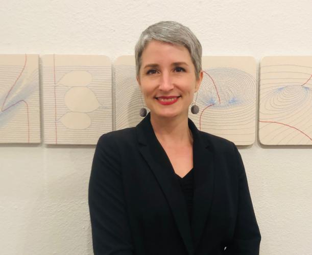 SFA faculty artist Candace Hicks stands in front of works from her Notes for String Theory exhibition