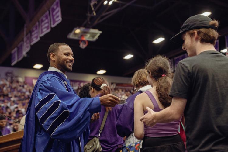 Dr. Kent Willis hands new Lumberjacks a silver challenge coin