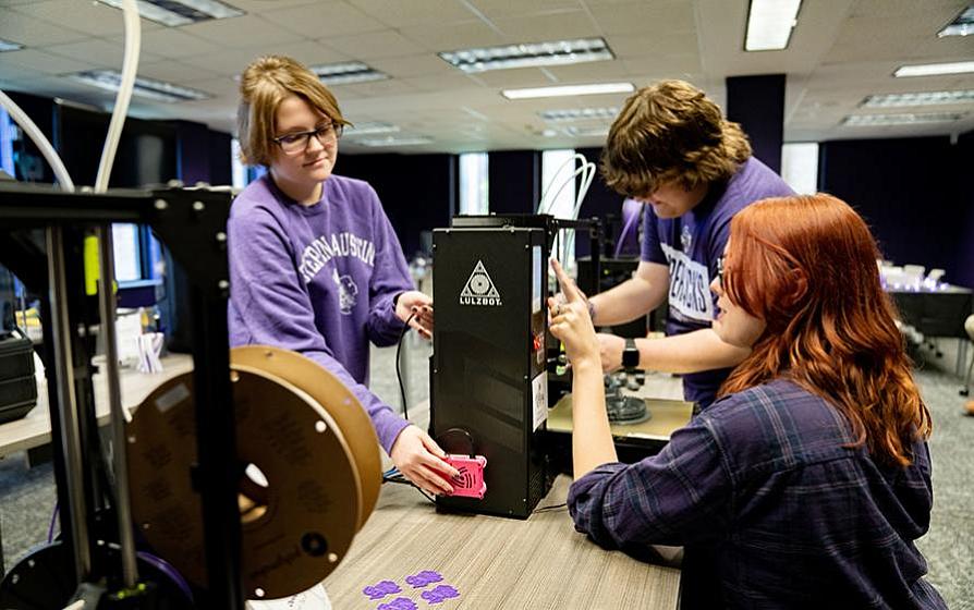 Students in the makerspace using a 3D printer